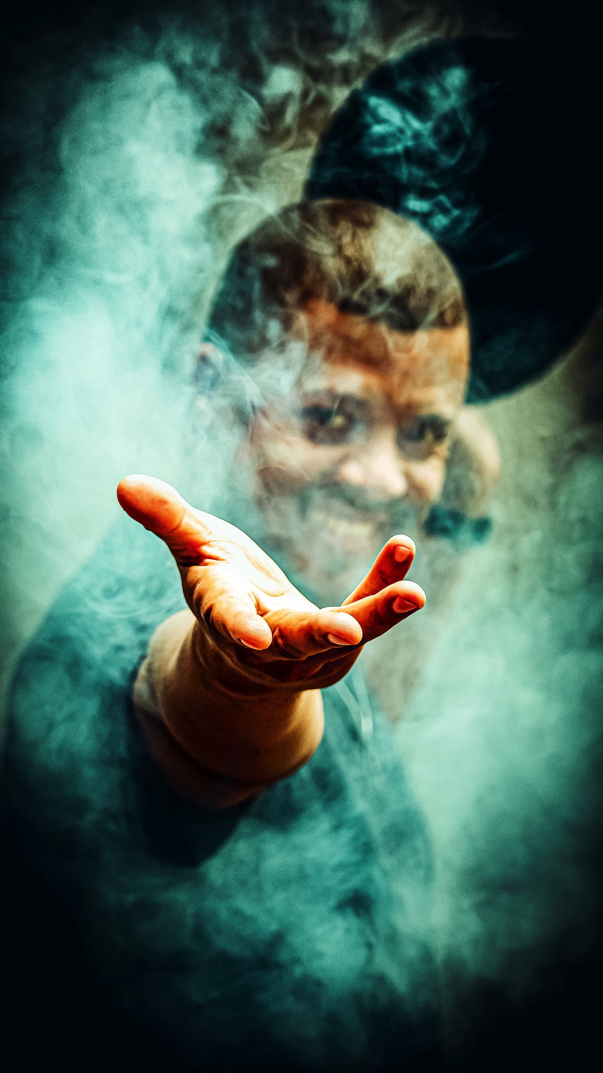 Dramatic fine art portrait of Brionne with a reaching hand emerging through swirling teal smoke, face half-revealed in the mist