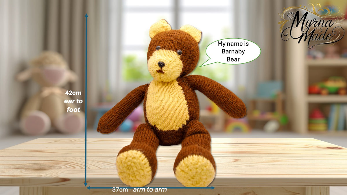 Knitted teddy bear with measurement details and 'Myrna Made' branding on a wooden surface.