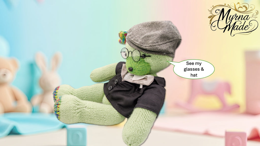 Knitted teddy bear character wearing glasses and a hat with 'Myrna Made' branding.