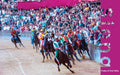 Jockeys in colourful contrada silks racing on horseback around the Campo at the Palio di Siena with packed grandstands