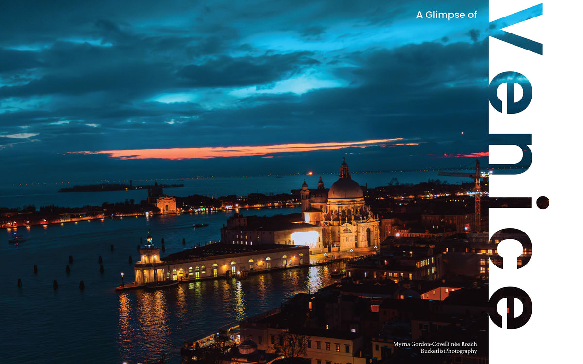 Aerial view of Santa Maria della Salute dome and Venice lagoon at sunset with dramatic teal and orange sky